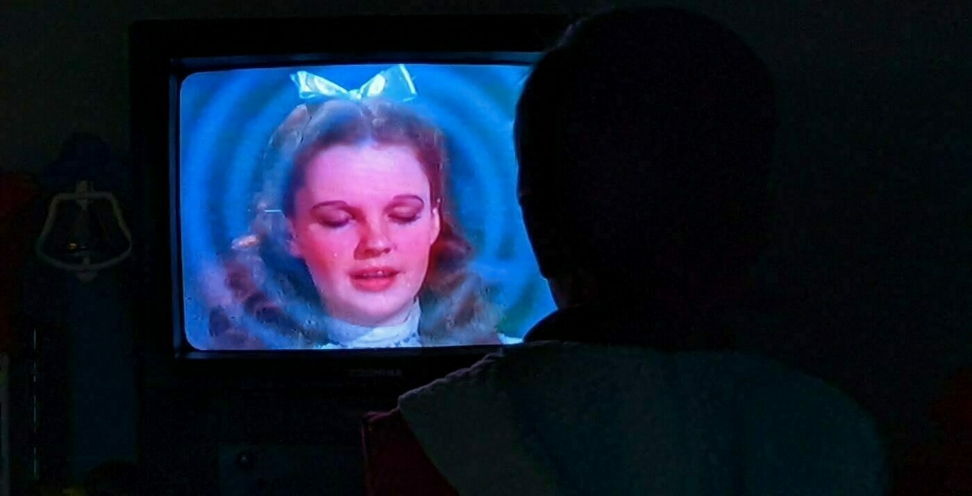 Silhouette of a child watching The Wizard of Oz on TV.